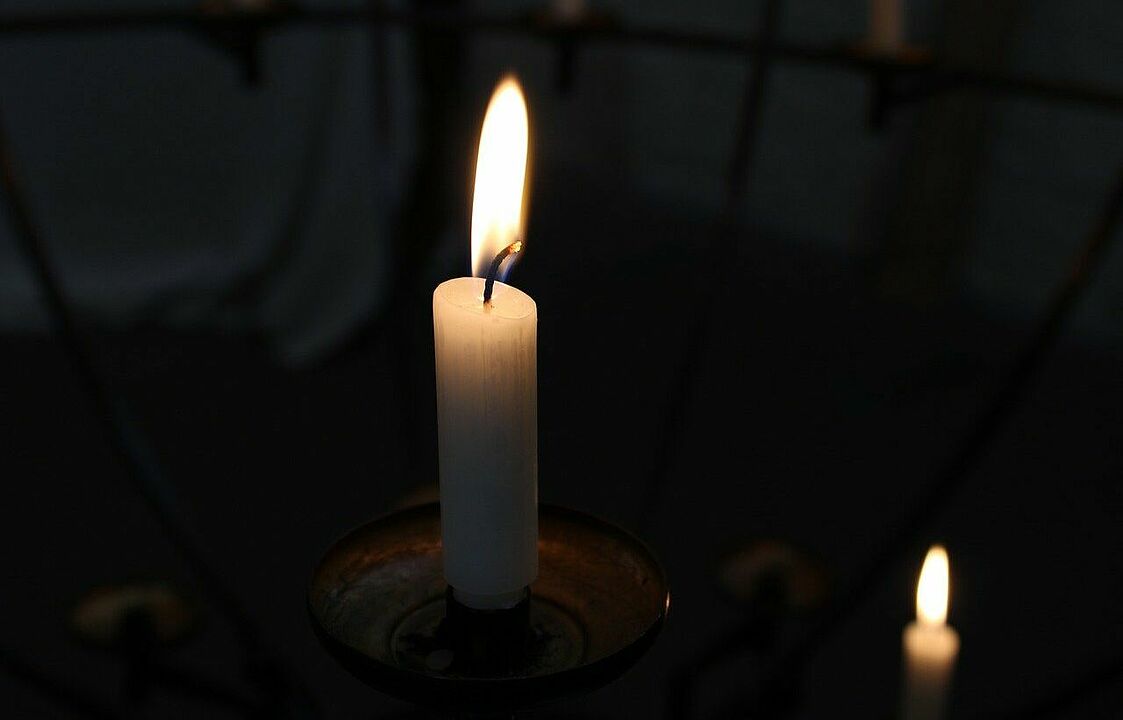 Zwei Kerzen vor schwarzem Hintergrund